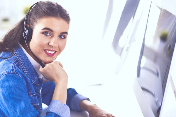 Retrato de mulher de negócios bonita trabalhando em sua mesa com fone de ouvido e laptop — Fotografia de Stock