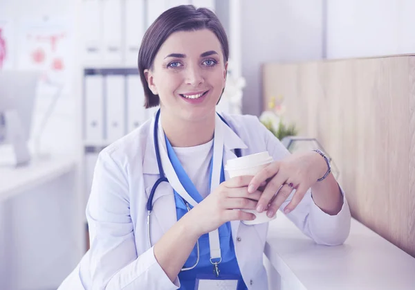 Retrato de médico profissional feminino segurando xícara de café — Fotografia de Stock