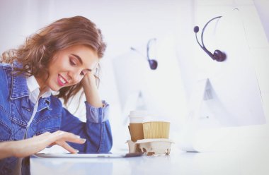 Ofiste dijital tablet kullanan genç bir kadın