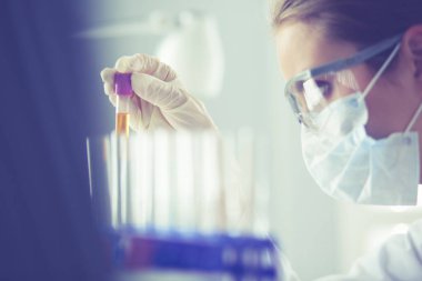 Laboratuvarda sıvı yeşil çözeltiye bakan bir tıbbi veya bilimsel araştırmacı ya da doktor