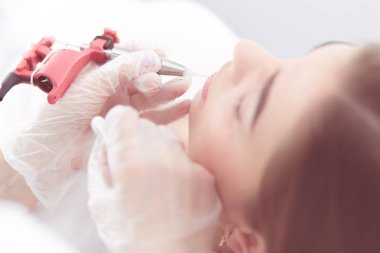 Kırmızı dudaklı genç bir kız kalıcı makyaj, mikro pigmentasyon