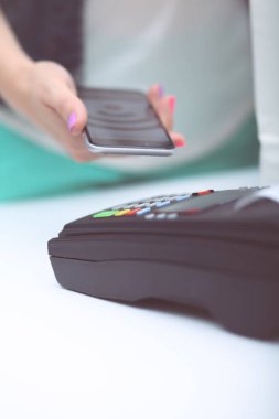 Müşteri ile smartphone Nfc teknolojisi kullanılarak dükkanda ödüyor. NFC teknolojisi. Müşteri ödeme.