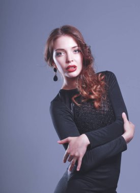 Gri arka plan üzerinde siyah elbiseli mutlu genç kadın portresi