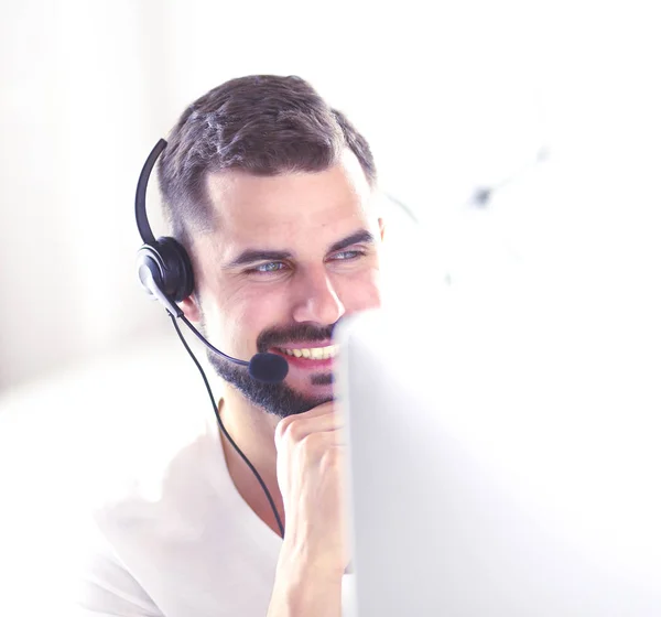 Porträtt av en ung man med ett headset framför en bärbar dator — Stockfoto