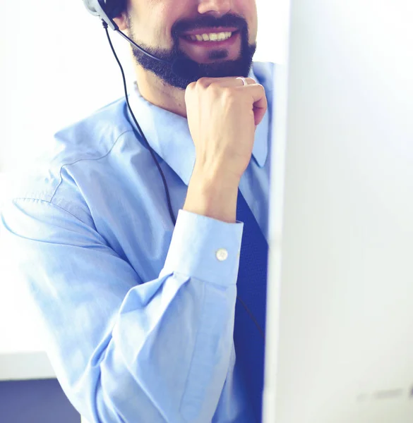 Porträt eines jungen Mannes mit Headset vor einem Laptop — Stockfoto