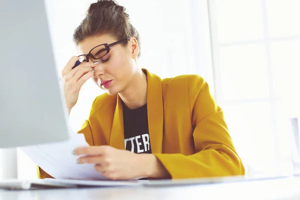 Retrato de una joven mujer de negocios cansada usando laptop y trabajando — Foto de Stock