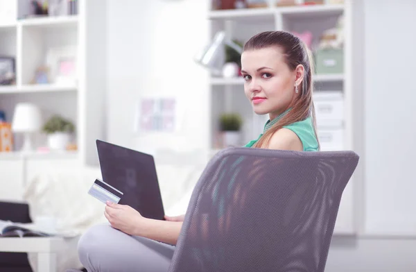 Schöne junge brünette Frau zu Hause sitzt auf Sofa oder Sofa mit ihrem Laptop-Computer — Stockfoto