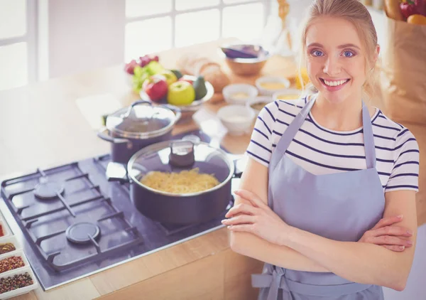 Jonge vrouw in de buurt van bureau in de keuken — Stockfoto