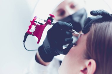 Mikro patenli kaşlar güzellik salonunda çalışır. Kaşları renkli bir kadın.