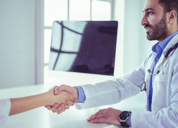 Doctor estrechando la mano al paciente en la oficina en el escritorio — Foto de Stock