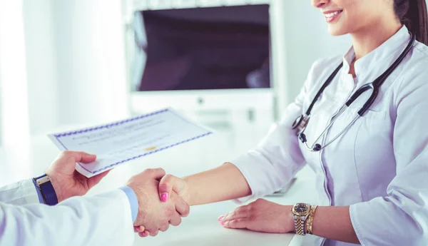 Médico aperta as mãos com um paciente isolado em fundo branco — Fotografia de Stock