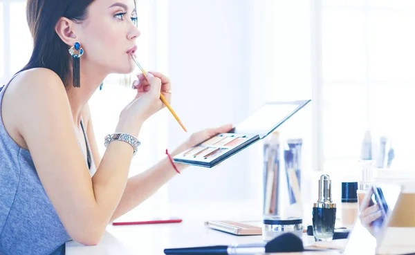 Brünette Frau beim Make-up für ein Date am Abend vor dem Spiegel — Stockfoto