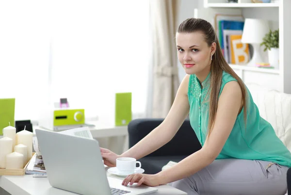 Mooie jonge brunette vrouw thuis zittend op Bank of bank met behulp van haar laptop computer — Stockfoto