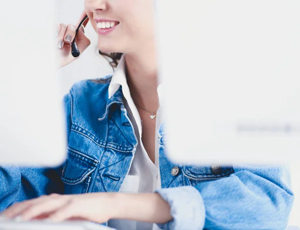 Felice affascinante giovane donna seduta e lavorare con il computer portatile utilizzando cuffie in ufficio — Foto Stock