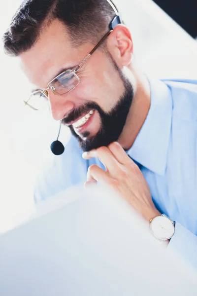 Felice uomo d'affari con auricolare seduto alla scrivania in ufficio moderno — Foto Stock