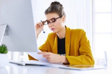 Dizüstü bilgisayar ve çalışma kullanarak genç yorgun bir iş kadını Portresi