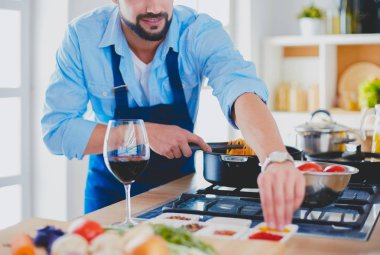 Adam ev mutfağında lezzetli ve sağlıklı yemekler hazırlıyor.