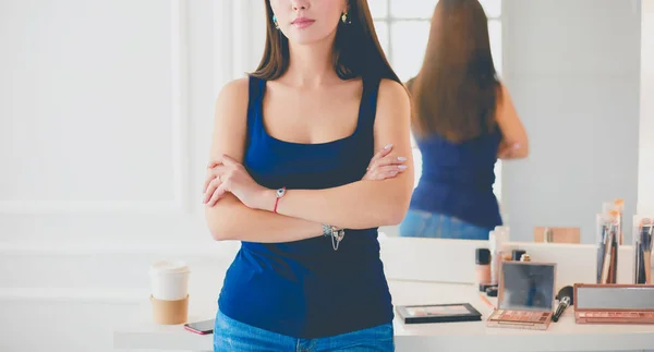 Femme debout avec les mains pliées dans son salon — Photo