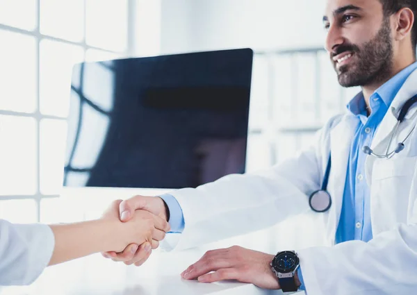 Doctor estrechando la mano al paciente en la oficina en el escritorio — Foto de Stock