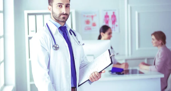 Sorrindo médico homem de pé na frente de sua equipe e paciente — Fotografia de Stock