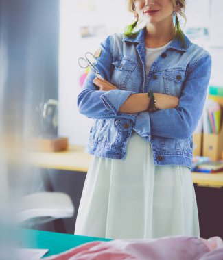 Moda tasarımcısı kadın stüdyoda tasarımları üzerinde çalışıyor.