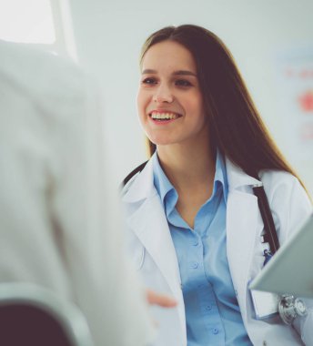 Doktor ve hasta masada otururken bir şey tartışıyorlar. İlaç ve sağlık hizmetleri kavramı