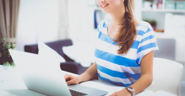 Elinde evrakları olan kadın masanın üstünde oturuyor.