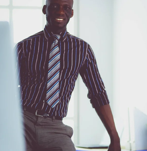 Afrikanischer Architekt arbeitet mit Computer und Bauplänen im Büro — Stockfoto