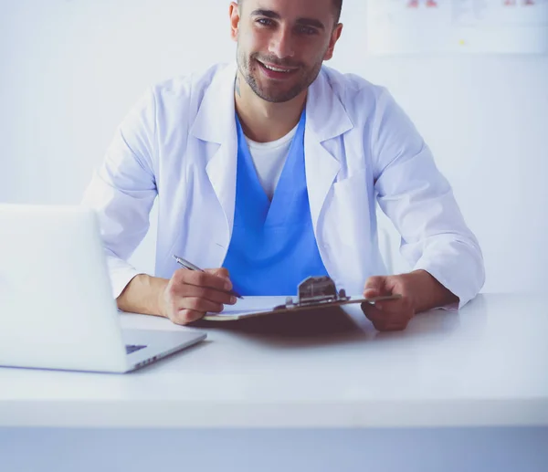 Porträt eines männlichen Arztes mit Laptop am Schreibtisch in der Arztpraxis — Stockfoto