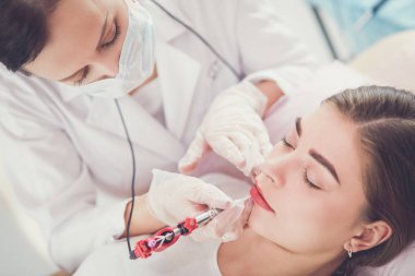 Kırmızı dudaklı genç bir kız kalıcı makyaj, mikro pigmentasyon