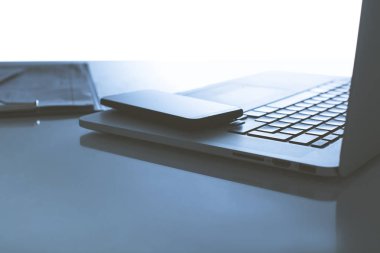Dizüstü bilgisayar, klavye, akıllı telefon ve kalemiçeren ofis masası