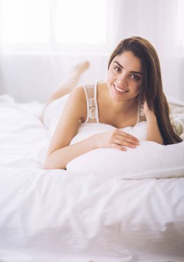 Güzel bir kadın yatağında uzanıyor.