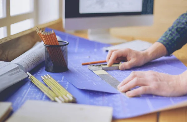 Arquitecto trabajando en mesa de dibujo en la oficina —  Fotos de Stock