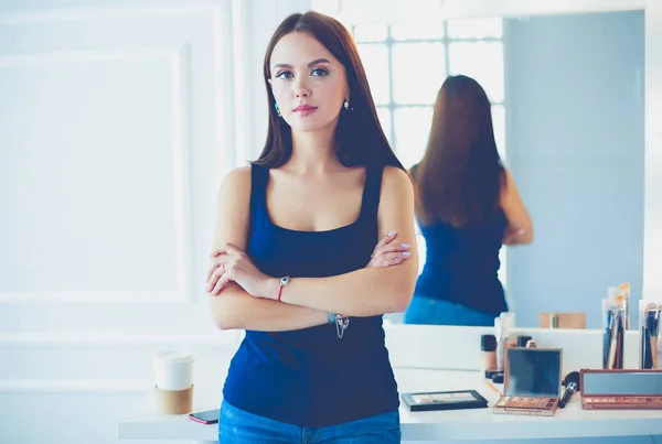 Mujer de pie con las manos dobladas en su salón —  Fotos de Stock