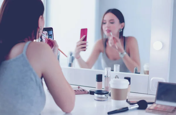 Beauty-Bloggerin filmt Make-up-Anleitung mit Smartphone vor Spiegel — Stockfoto