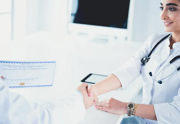 Doctor schudt handen met een patiënt geïsoleerd op witte achtergrond — Stockfoto