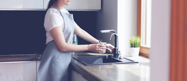 Женские руки наполняют стакан воды — стоковое фото
