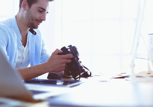 Retrato de jovem designer sentado no estúdio gráfico na frente de laptop e computador enquanto trabalhava online. — Fotografia de Stock