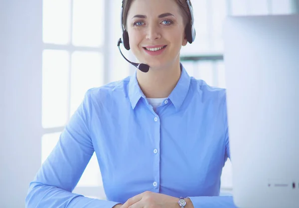 Ernstige mooie jonge vrouw die werkt als support telefoon operator met headset in het kantoor — Stockfoto