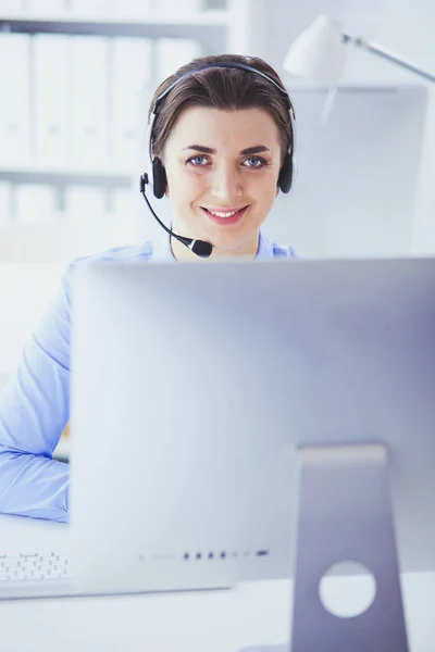 Sérieux jolie jeune femme travaillant comme opérateur de téléphone de soutien avec casque dans le bureau — Photo