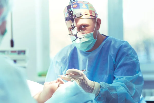 Homem cirurgião no trabalho na sala de cirurgia — Fotografia de Stock