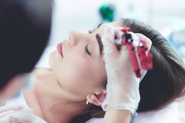 Una joven con labios rojos maquillaje permanente, micropigmentación —  Fotos de Stock