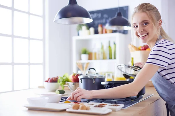 Schöne junge Frau kocht zu Hause in der Küche — Stockfoto