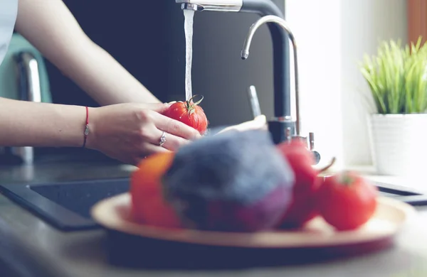 Kobieta mycie pomidorów w zlewie w kuchni zbliżenie — Zdjęcie stockowe