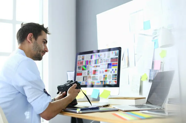 İnternette çalışırken bilgisayarın ve dizüstü bilgisayarın önünde grafik stüdyosunda oturan genç tasarımcının portresi. — Stok fotoğraf