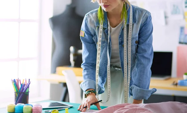 Mulher designer de moda trabalhando em seus projetos no estúdio — Fotografia de Stock