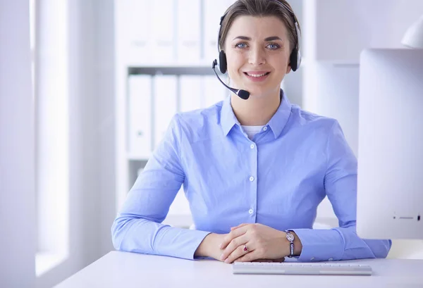 Ernsthafte hübsche junge Frau arbeitet als Telefonistin mit Headset im Büro — Stockfoto