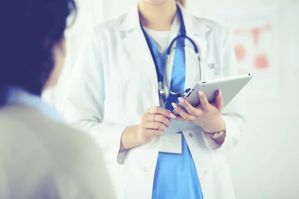 Female doctor giving a consultation to a patient and explaining medical informations and diagnosis