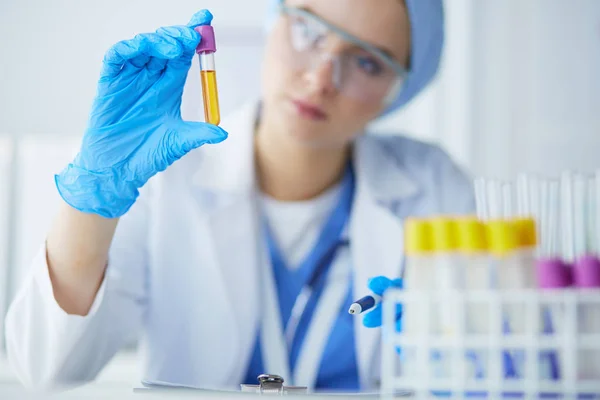 Assistente de laboratório analisando uma amostra de sangue — Fotografia de Stock