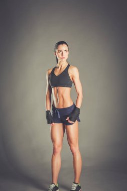 Spor giyim siyah arka plan karşı poz kas genç kadın.